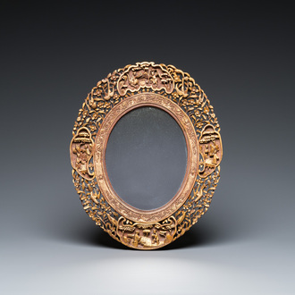 An oval Chinese reticulated gilded wooden mirror, 19/20th C.