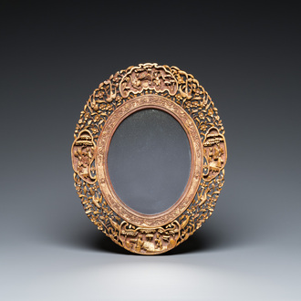 An oval Chinese reticulated gilded wooden mirror, 19/20th C.