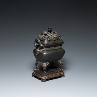 A Chinese bronze censer with reticulated 'dragon' cover on bronze stand, 17th C.