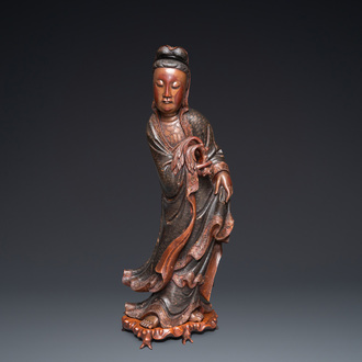 A large Chinese gilt-lacquered wood figure of Guanyin on a carved wooden stand, 17th C.