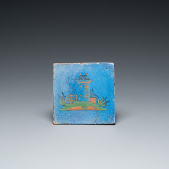 A rare polychrome Dutch Delft tile with a castle on a berretino blue ground, 17th C.