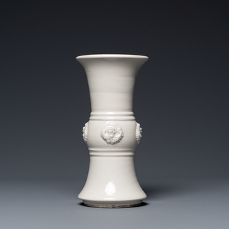 Vase de forme 'gu' en porcelaine blanc de Chine orné de têtes de dragons, 18/19ème