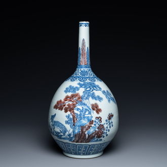 A Chinese blue, white and copper-red bottle vase with a deer and birds among blossoming branches, 19th C.