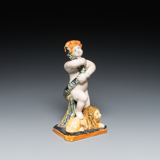 A polychrome Brussels faience sculpture of a putto with a snake standing on a lion, late 18th C.