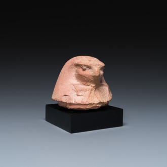 An Egyptian light brown limestone canopic lid in the shape of a falcon head, Late Period