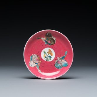 A rare Chinese famille rose ruby-ground 'three butterflies' saucer, Yongzheng