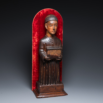 A partly gilded and polychromed wood sculpture of a monk holding a chest, probably Spain, 16th C.