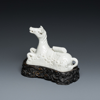 A Chinese white-glazed brush rest in the shape of a resting horse in a wavy sea, 18th C.