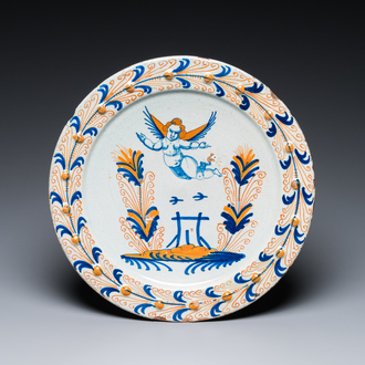 An exceptional polychrome Dutch maiolica dish with a flying putto above a fence, probably Haarlem, 1st half 17th C.