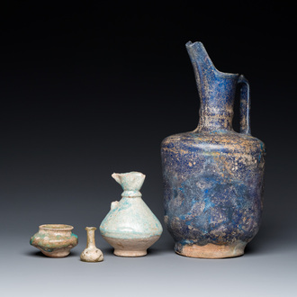 Three blue- and turquoise-glazed Islamic pottery wares and a glass bottle, Kashan and Raqqa, 12th C. and later