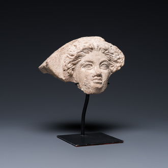 A Greek terracotta with white engobe antefix in the shape of a woman's head, 5/4th C. b.C.
