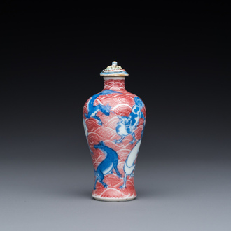 A Chinese blue, white and copper-red 'dogs' snuff bottle, 19th C.