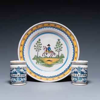 Two Dutch Delft blue and white drug jars and a polychrome Brussels faience dish with a rider on horseback, 18th C.