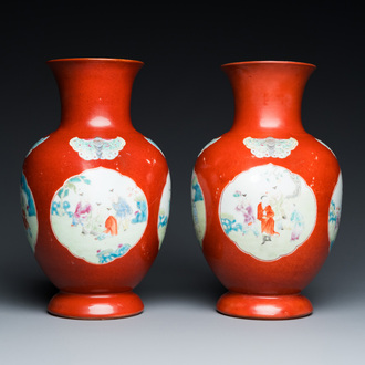 Paire de vases en porcelaine de Chine famille rose à fond corail à décor de garçons jouant, 18/19ème