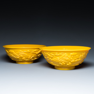 A pair of Chinese yellow Beijing glass bowls with figures in mountainous landscapes, 19/20th C.