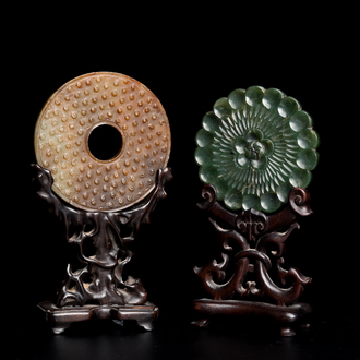 A Chinese celadon and russet jade 'bi' disc and a spinach green flower-shaped pendant on wooden stands, Ming and Qing