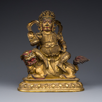 A Sino-Tibetan gilt bronze sculpture of Vaishravana on a Buddhist lion, probably 17th C.