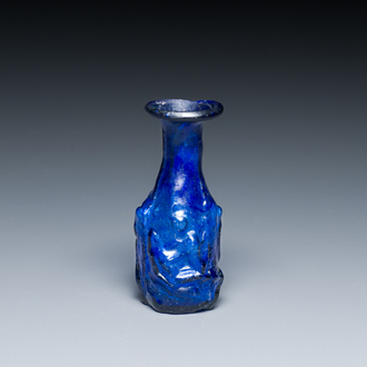 A Roman ‘Sidonian’ dark blue 'erotic subject' molded glass bottle, Eastern Mediterranean, ca. 1st C.
