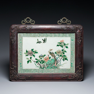 A Chinese relief-decorated famille verte 'peacock' plaque in a fine carved hongmu wooden frame, 19th C.