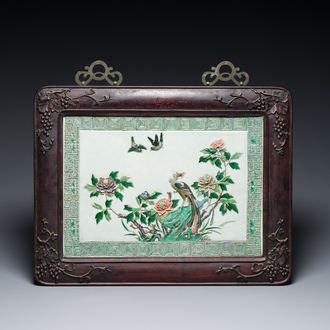 Plaque en porcelaine de Chine famille verte à décor en relief d'un paon dans un cadre en bois de hongmu sculpté, 19ème