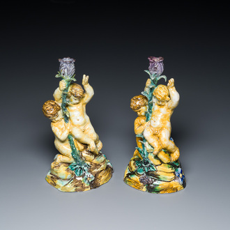 A pair of polychrome Talavera pottery candlesticks with putti on a branch, Spain, 18th C.