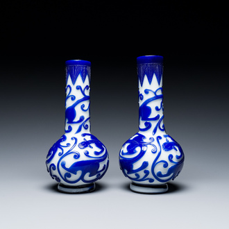 A pair of Chinese overlay Beijing glass bottle vases with chilongs in blue on white, 19th C.