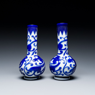 Een paar Chinese flesvormige vazen met chilongs in meerlagig blauw en wit Peking glas, 19e eeuw