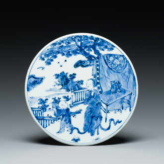 A Chinese round blue and white plaque with a lady and a boy, 19th C.