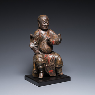 Een Chinese gelakte en gepolychromeerde houten sculptuur van een boeddhistische wachter, Ming