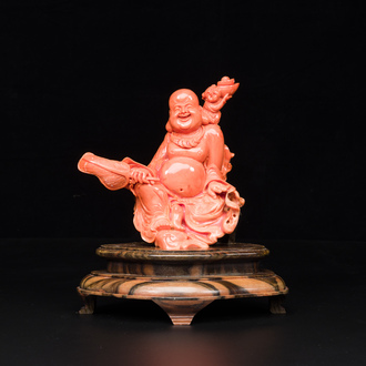 A Chinese red coral figure of a laughing Buddha on wooden stand, 19/20th C.