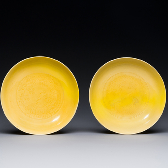 A pair of Chinese monochrome yellow-glazed saucers with incised designs of pine and cranes, Yongzheng mark and of the period