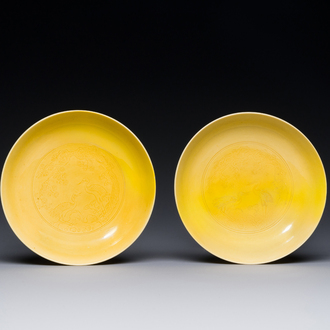 A pair of Chinese monochrome yellow-glazed saucers with incised designs of pine and cranes, Yongzheng mark and of the period