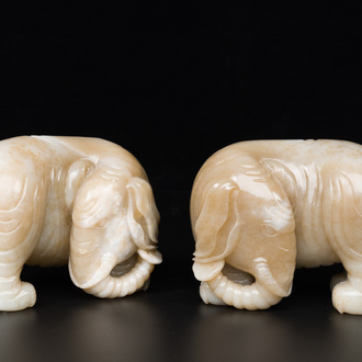 Een paar Chinese witte en roodbruine jade sculpturen van een olifant, Qianlong