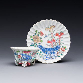 A Chinese famille rose relief-decorated cup and saucer, Yongzheng