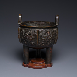 A Chinese archaistic bronze tripod censer on wooden stand, 'ding', Song/Ming