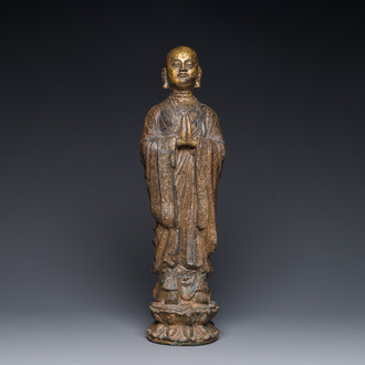 A Chinese gilt cast iron figure of a standing monk, Ming