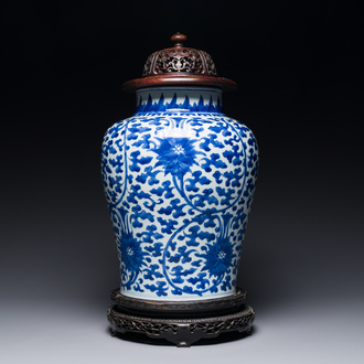 Pot en porcelaine de Chine en bleu et blanc à décor de rinceaux de lotus au couvercle et socle en bois, Kangxi