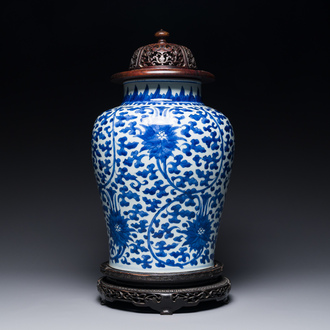 A Chinese blue and white 'lotus scroll' jar with wooden cover and stand, Kangxi