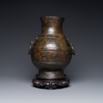 Vase de forme 'hu' en bronze aux anses en forme de taotie dans le style de Han sur socle en bois, Chine, Ming