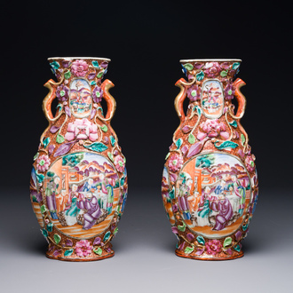 A pair of Chinese Canton famille rose 'mandarin subject' vases with floral relief design, Qianlong