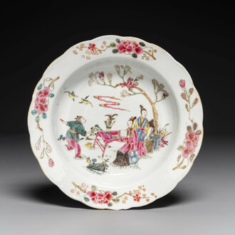 Assiette en porcelaine de Chine famille rose à décor de figures dans un jardin, Yongzheng