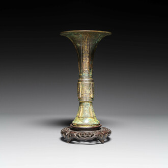 A Chinese bronze Shang-style 'gu' vase on wooden stand, 19/20th C.
