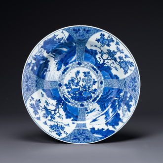 Plat en porcelaine de Chine en bleu et blanc à décor de panneaux paysagers et floraux, Kangxi