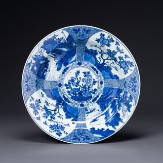 A Chinese blue and white dish with landscape and floral panels, Kangxi