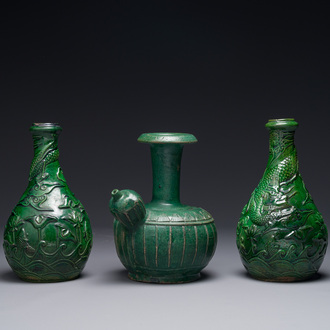 Two Chinese monochrome green-glazed stoneware 'dragon' vases and a kendi, Fujian kiln, late Ming