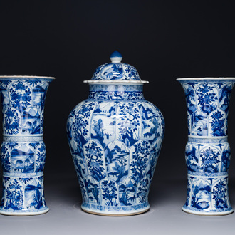Een Chinees blauw-wit kaststel met drie vazen met floraal en landschapsdecor, Kangxi
