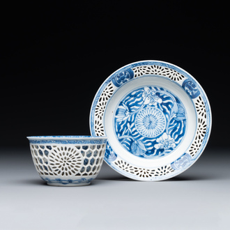 A Chinese blue and white reticulated double-walled cup and saucer, Kangxi