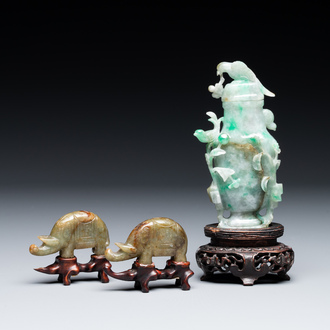 A pair of Chinese jade sculptures of elephants and a covered vase on wooden stands, 19th C.