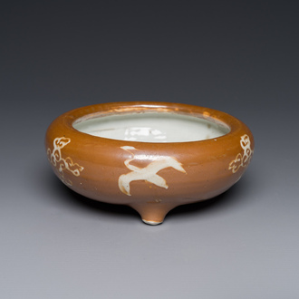 A rare Chinese Swatow slip-decorated brown-glazed tripod censer with cranes, Ming