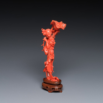 A Chinese red coral figure of a standing lady holding a flower, 19/20th C.